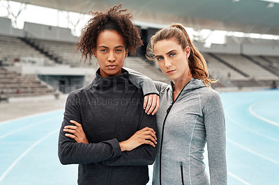 Buy stock photo Cropped portrait of two attractive young athletes standing together after a run on a track field during a training session