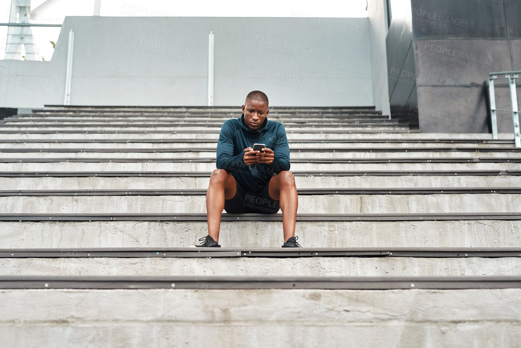 Buy stock photo African man, smartphone and sports, stairs and stadium for training, outdoor or workout on stands for wellness. Male athlete, technology and break in exercise for tournament, competition or contest