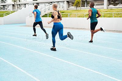 Buy stock photo Full length shot of a diverse group of athletes racing each other during an outdoor track and field workout session