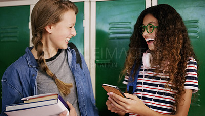 Buy stock photo Cropped shot of two young school kids having a chat before going to class inside of a school during the day