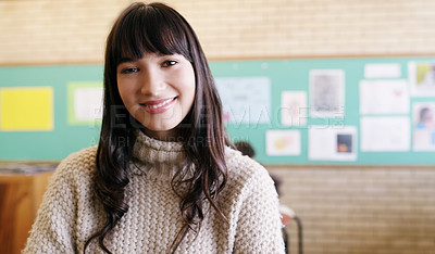 Buy stock photo Portrait of a cheerful young female teacher standing inside of her classroom during the day