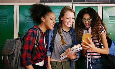 Buy stock photo Cropped shot of a group of young school kids browsing on a cellphone together while waiting to go to class inside of a school