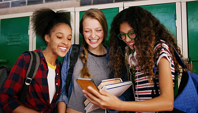 Buy stock photo Cropped shot of a group of young school kids browsing on a cellphone together while waiting to go to class inside of a school