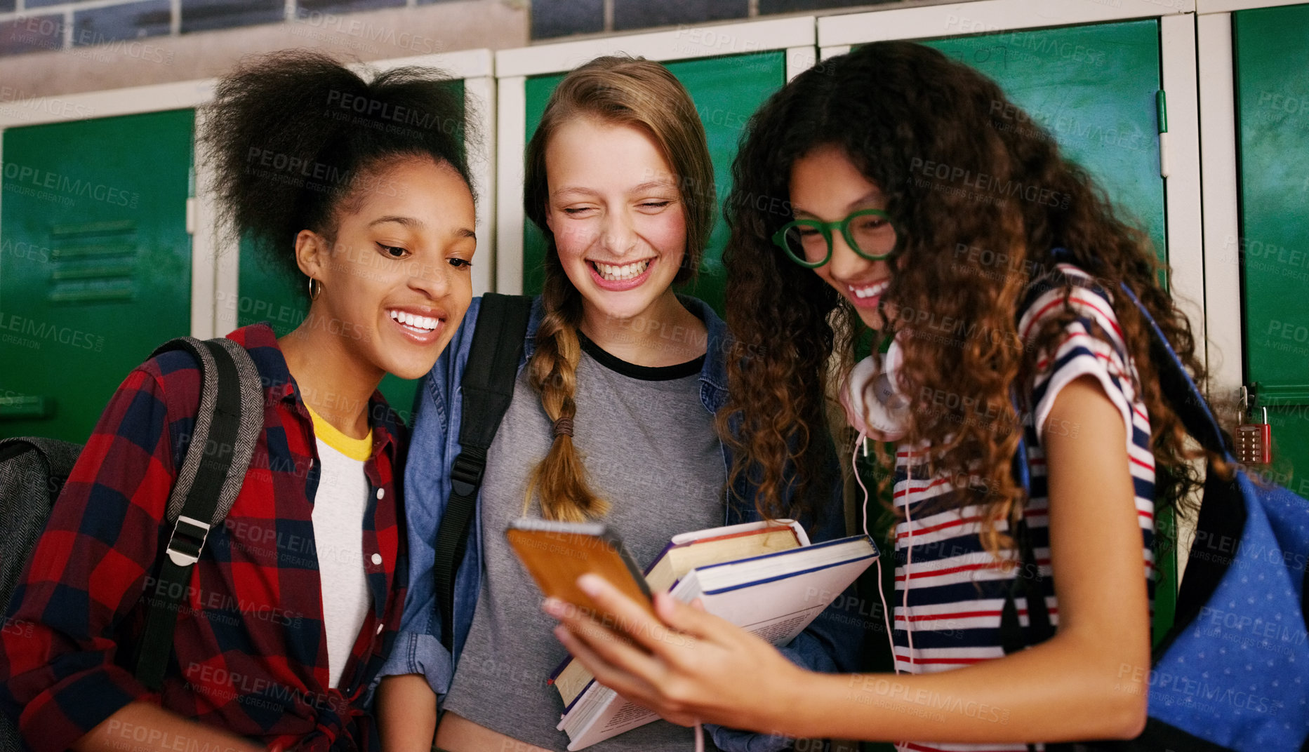 Buy stock photo Cropped shot of a group of young school kids browsing on a cellphone together while waiting to go to class inside of a school