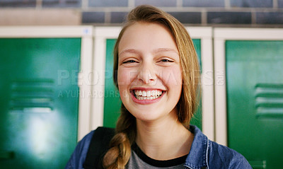 Buy stock photo Portrait of a cheerful young school kid smiling brightly while waiting to go to class inside of a school during the day