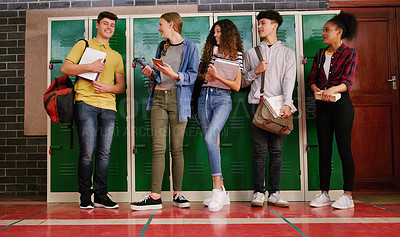 Buy stock photo Cropped shot of a group of cheerful young school kids talking to each other before class inside of a school during the day