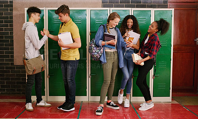 Buy stock photo Cropped shot of a group of cheerful young school kids talking to each other before class inside of a school during the day