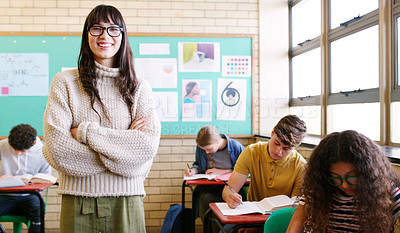 Buy stock photo Portrait of a cheerful young teacher giving class to a group of students inside of a school during the day