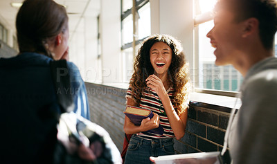 Buy stock photo Cropped shot of a cheerful young school kid laughing while hanging out with her friends in the hallway before class inside of a school