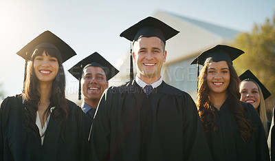 Buy stock photo Portrait of a group of cheerful young students standing together on graduation day outside during the day