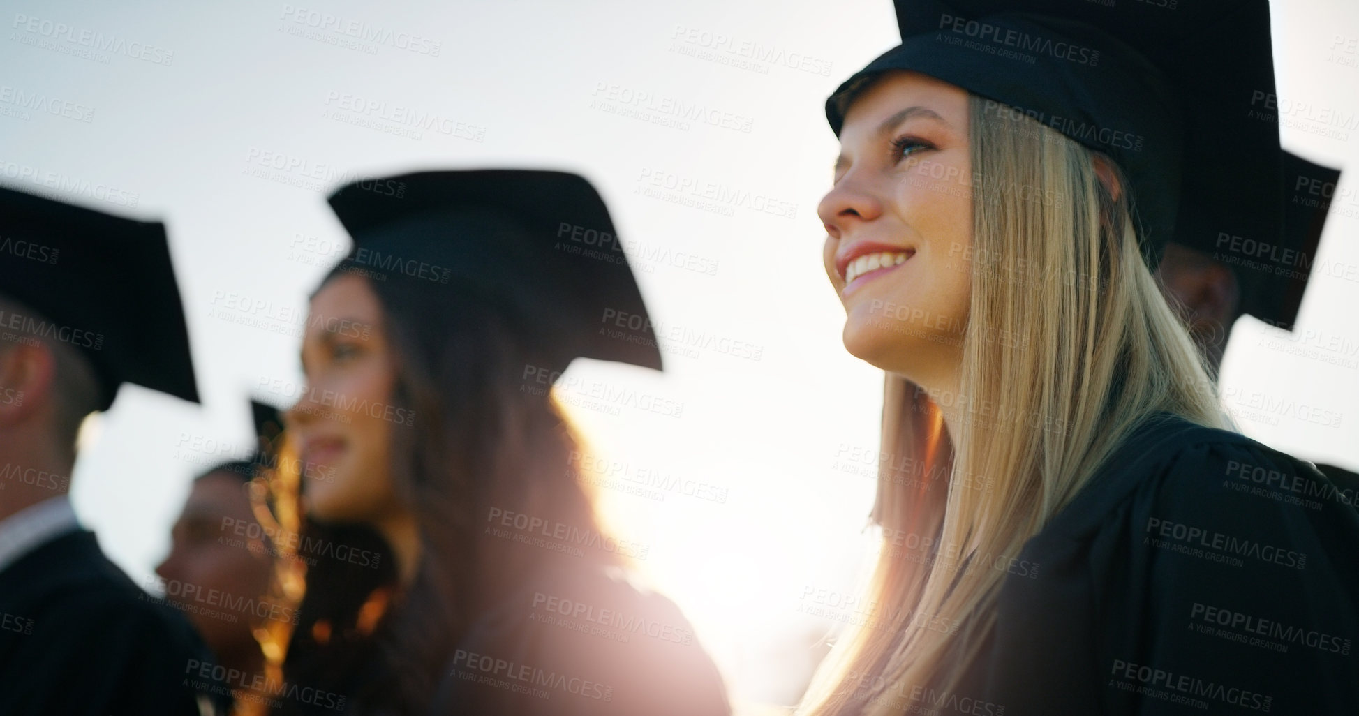 Buy stock photo Cropped shot of a group of cheerful young students standing together on graduation day outside during the day