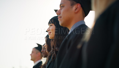 Buy stock photo Cropped shot of a group of cheerful young students standing together on graduation day outside during the day