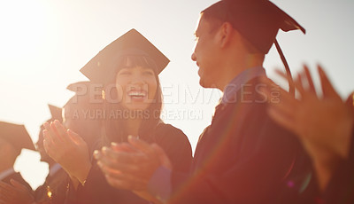 Buy stock photo Cropped shot of a group of cheerful young students standing together while clapping their hands on graduation day outside during the day