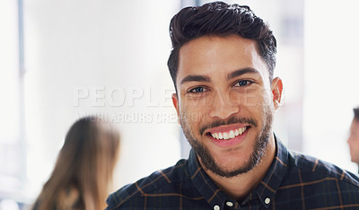 Buy stock photo Portrait of a young businessman sitting in an office with his colleagues in the background