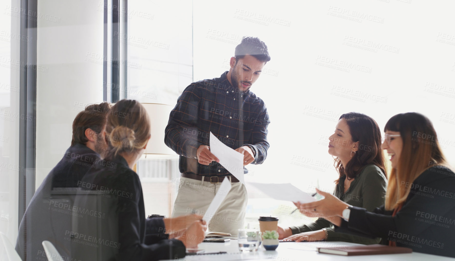 Buy stock photo Shot of a young businessman giving a presentation to his colleagues in an office