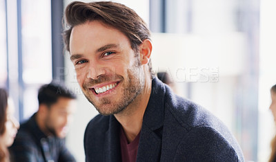 Buy stock photo Portrait of a young businessman sitting in an office with his colleagues in the background