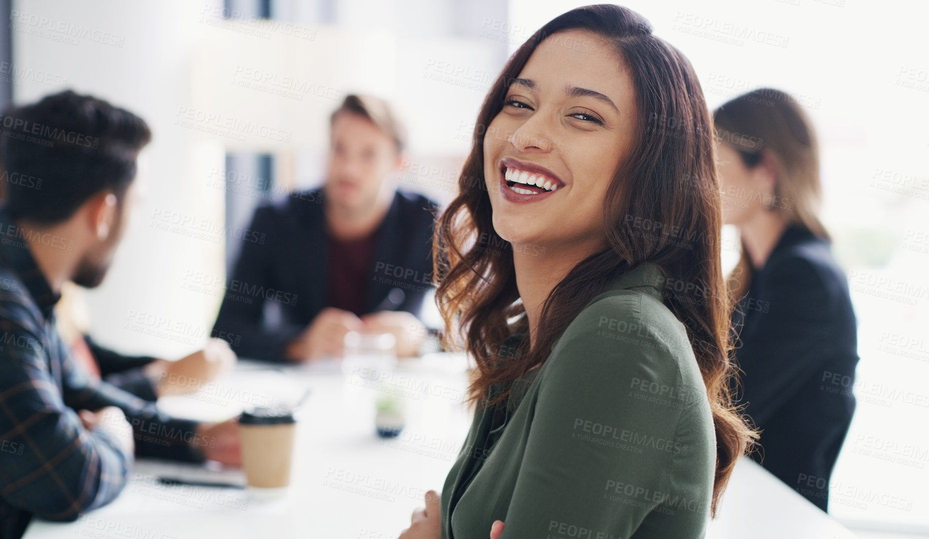 Buy stock photo Portrait of a young businesswoman sitting in an office with her colleagues in the background