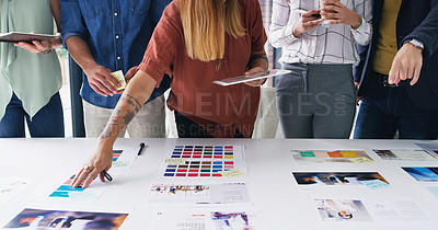 Buy stock photo Closeup shot of a group of designers going through paperwork together in an office