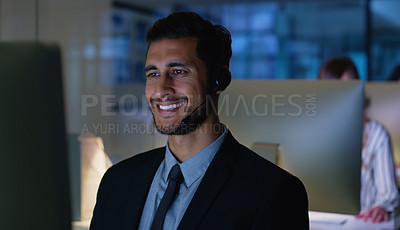 Buy stock photo Cropped shot of a handsome young businessman sitting in his office and wearing a headset while working on his computer