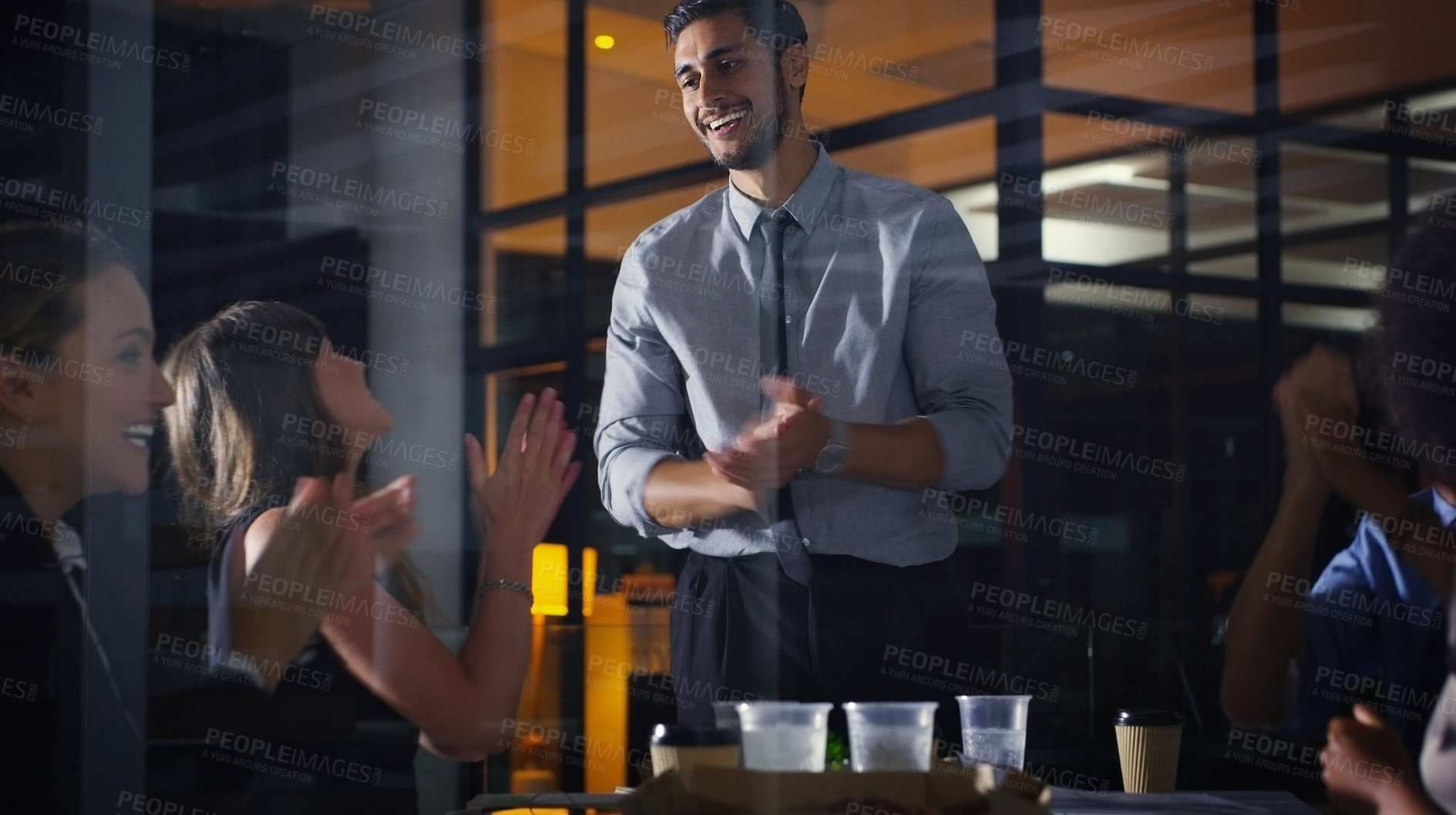 Buy stock photo Cropped shot of a diverse group of businesspeople clapping after a successful meeting in the office late at night