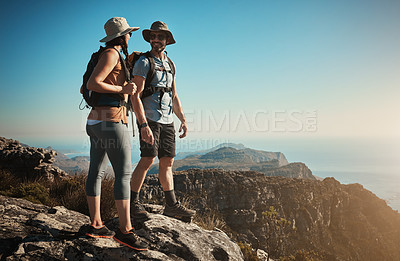 Buy stock photo Shot of a man and woman hiking up a mountain