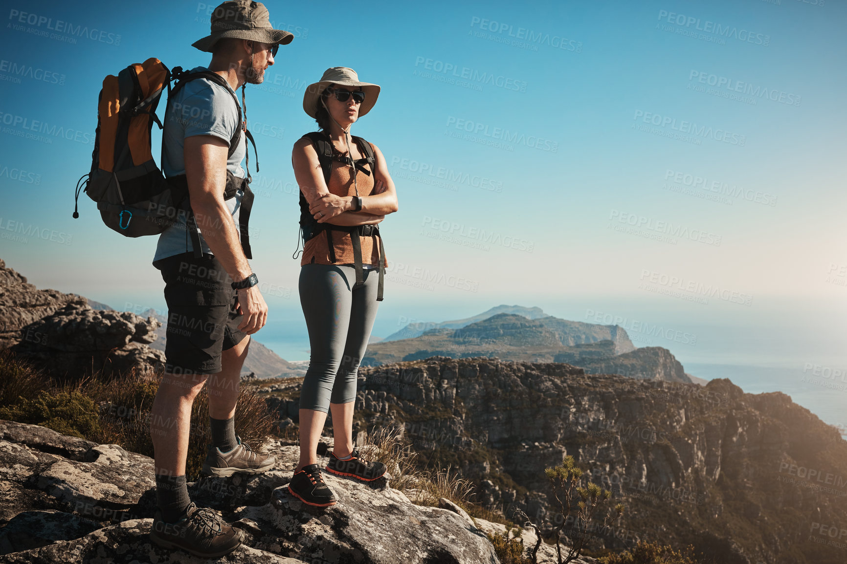 Buy stock photo Hiking, view and couple on mountain with travel for adventure, cliff trekking and mockup space. Fitness, nature trail and people for wellness and exercise achievement on blue sky, holiday or journey