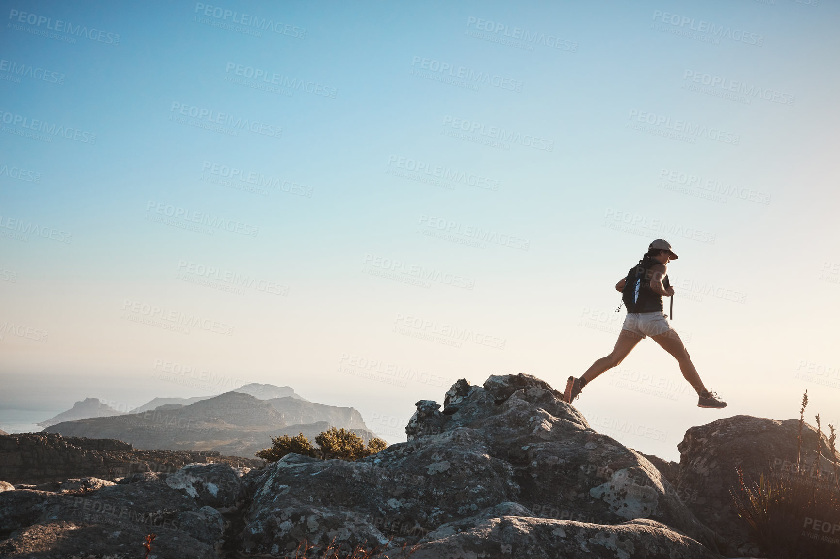 Buy stock photo Shot of a young woman hiking up a mountain