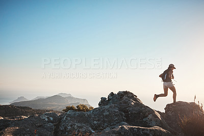Buy stock photo Shot of a young woman hiking up a mountain