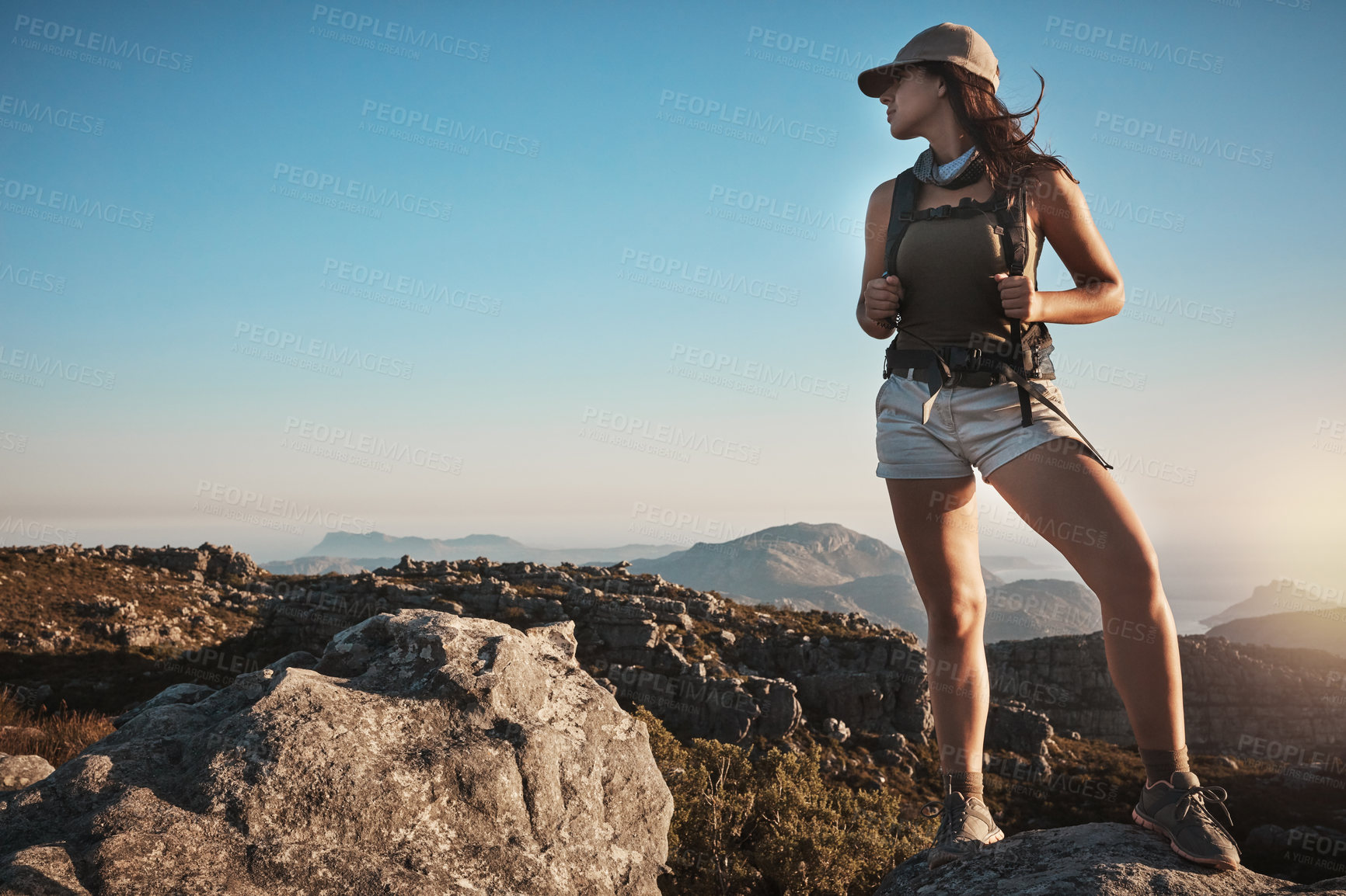 Buy stock photo Shot of a young woman hiking up a mountain