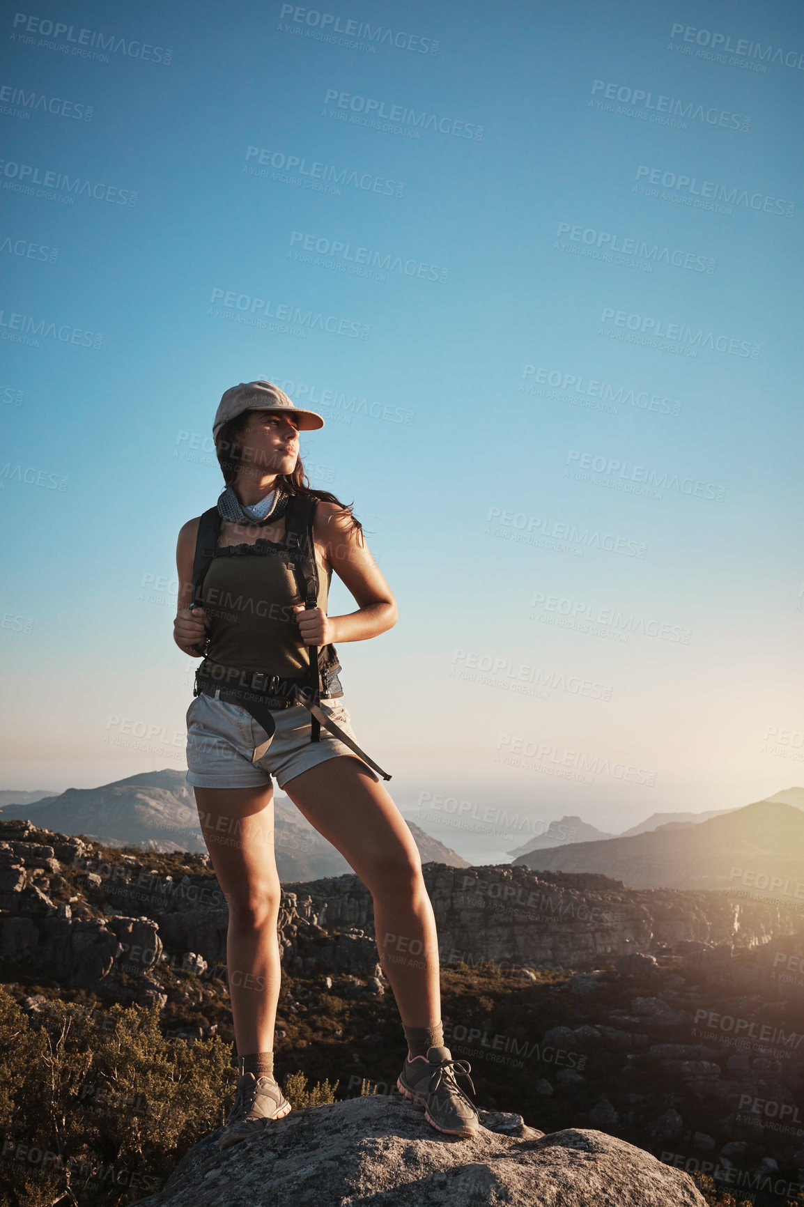 Buy stock photo Shot of a young woman hiking up a mountain