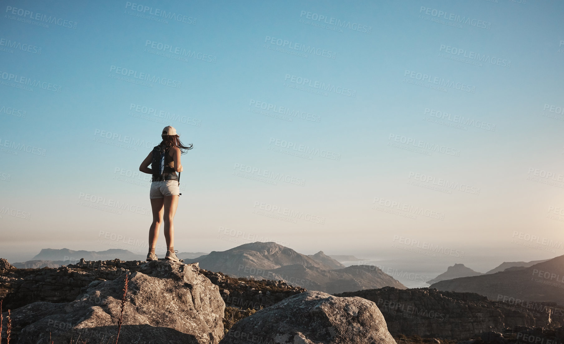 Buy stock photo Shot of a young woman hiking up a mountain