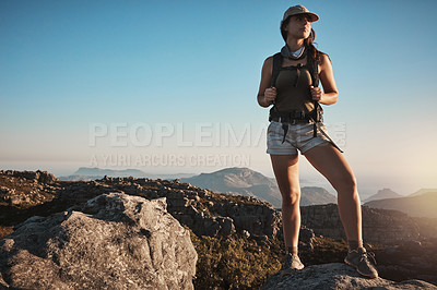 Buy stock photo Shot of a young woman hiking up a mountain