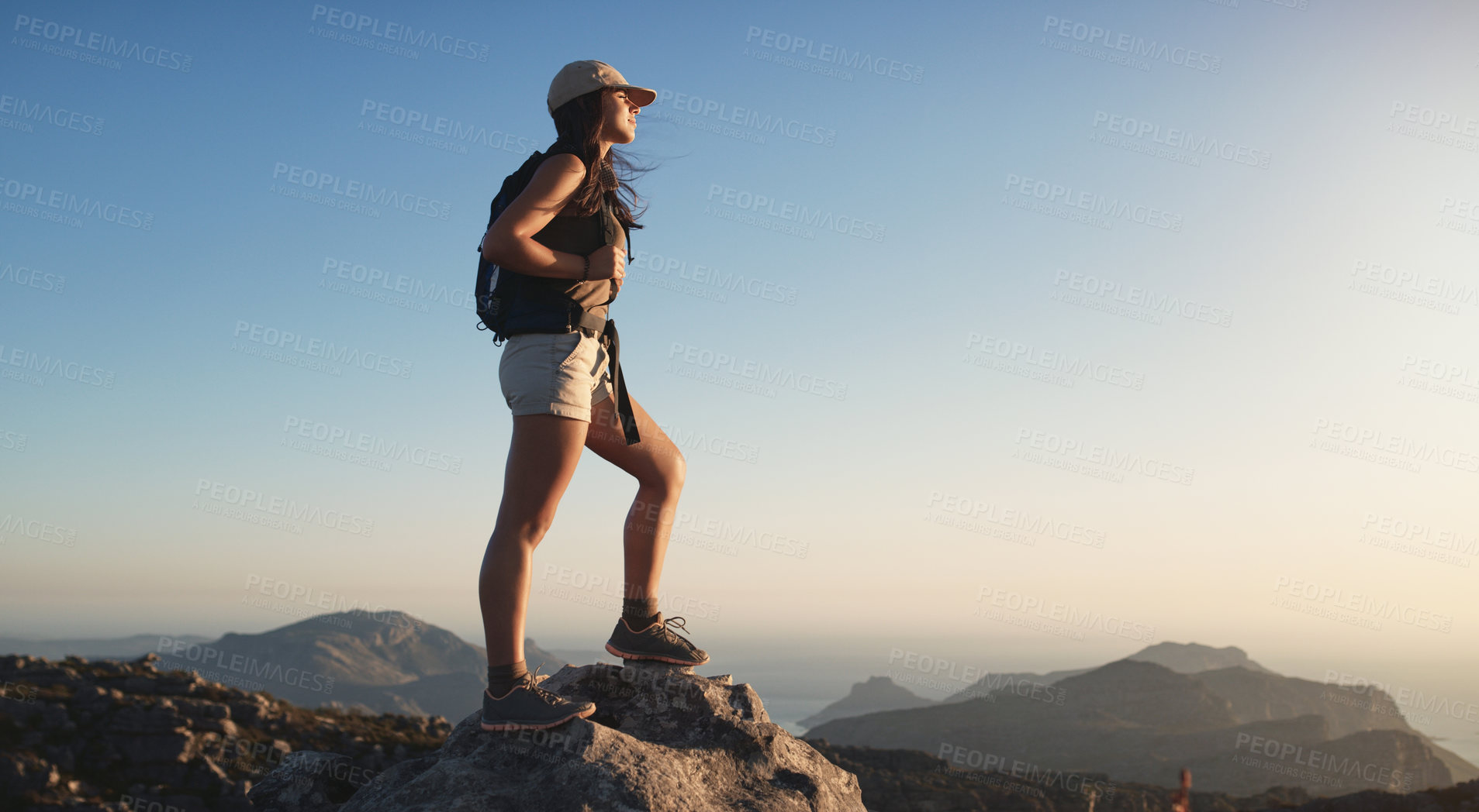 Buy stock photo Shot of a young woman hiking up a mountain