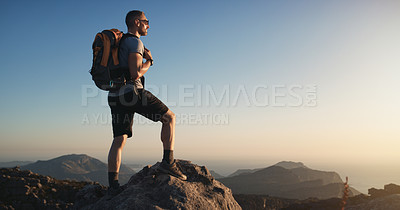Buy stock photo Shot of a mature man hiking up a mountain at sunset