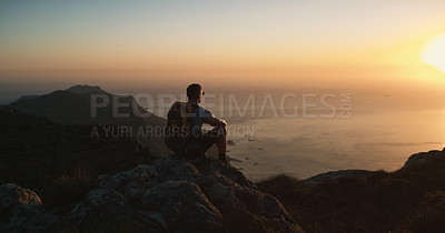 Buy stock photo Shot of a mature man hiking up a mountain at sunset