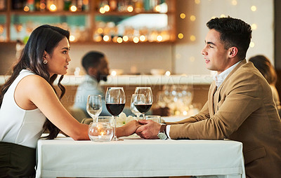 Buy stock photo Couple holding hands, date in restaurant and celebrate Valentines day holiday with love, romance and fine dining. Commitment, interracial relationship and man with woman together, trust and support