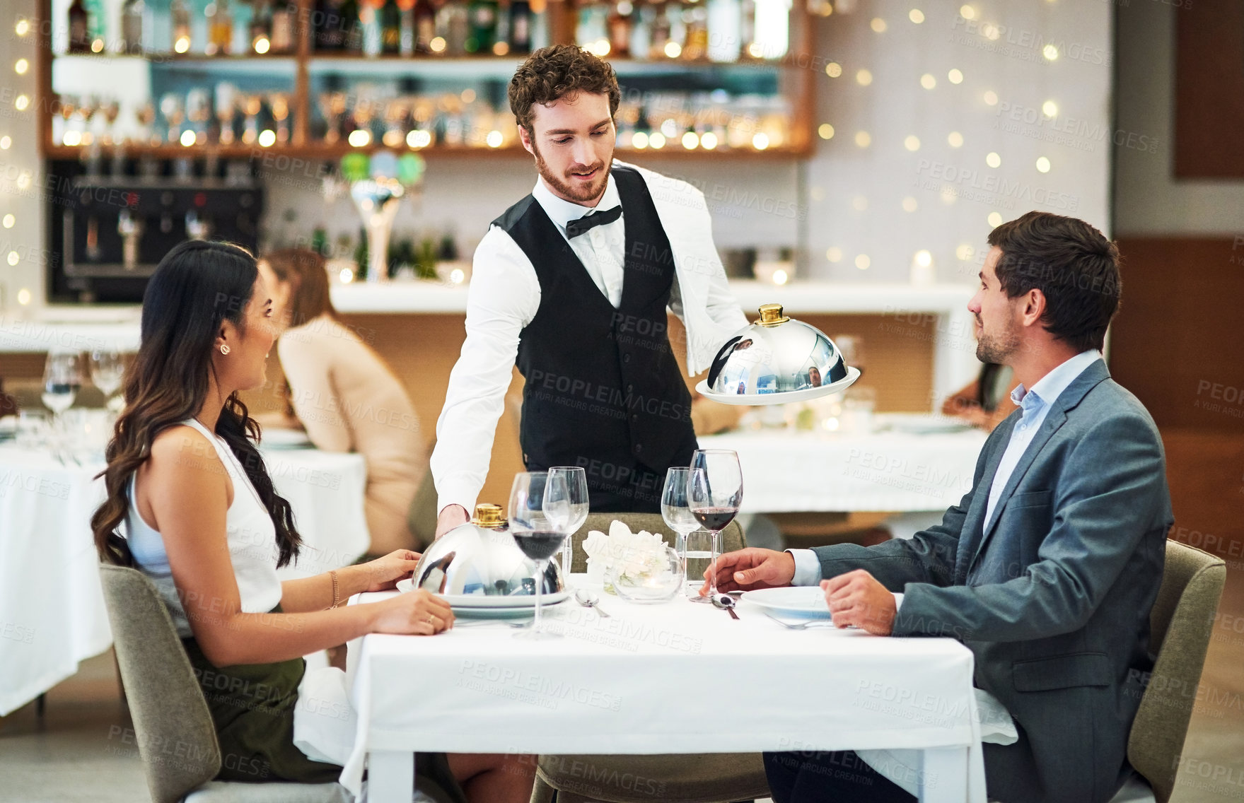 Buy stock photo Happy couple, restaurant server and fine dining food for valentines day date, love or romance in night. Man, woman and waiter with service, party and hospitality for dinner, bonding and celebration