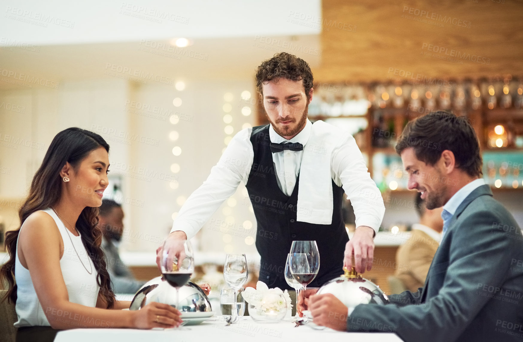 Buy stock photo Couple, restaurant server and fine dining at table for valentines day date, bonding and romance in night. Man, woman and waiter with food, service and hospitality for dinner, love and celebration