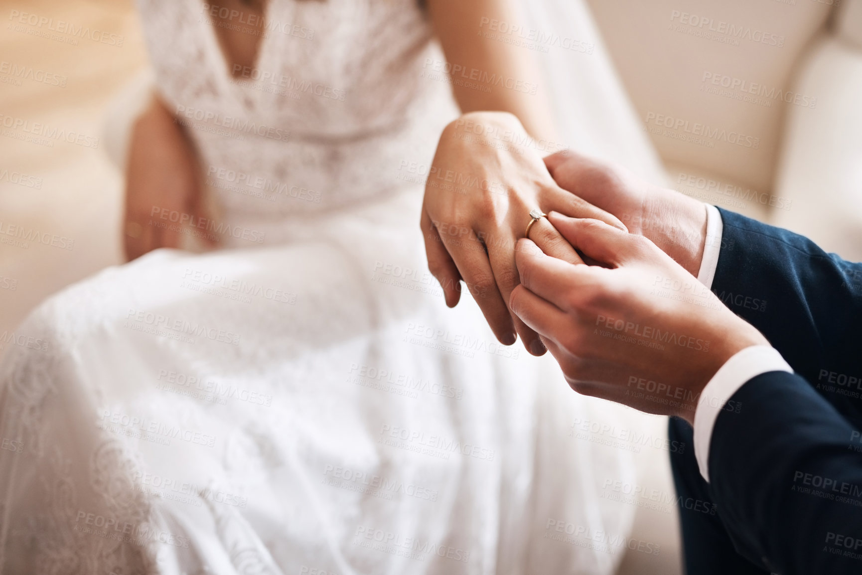 Buy stock photo Cropped shot of an unrecognizable groom putting a diamond ring on his wife's finger during their wedding