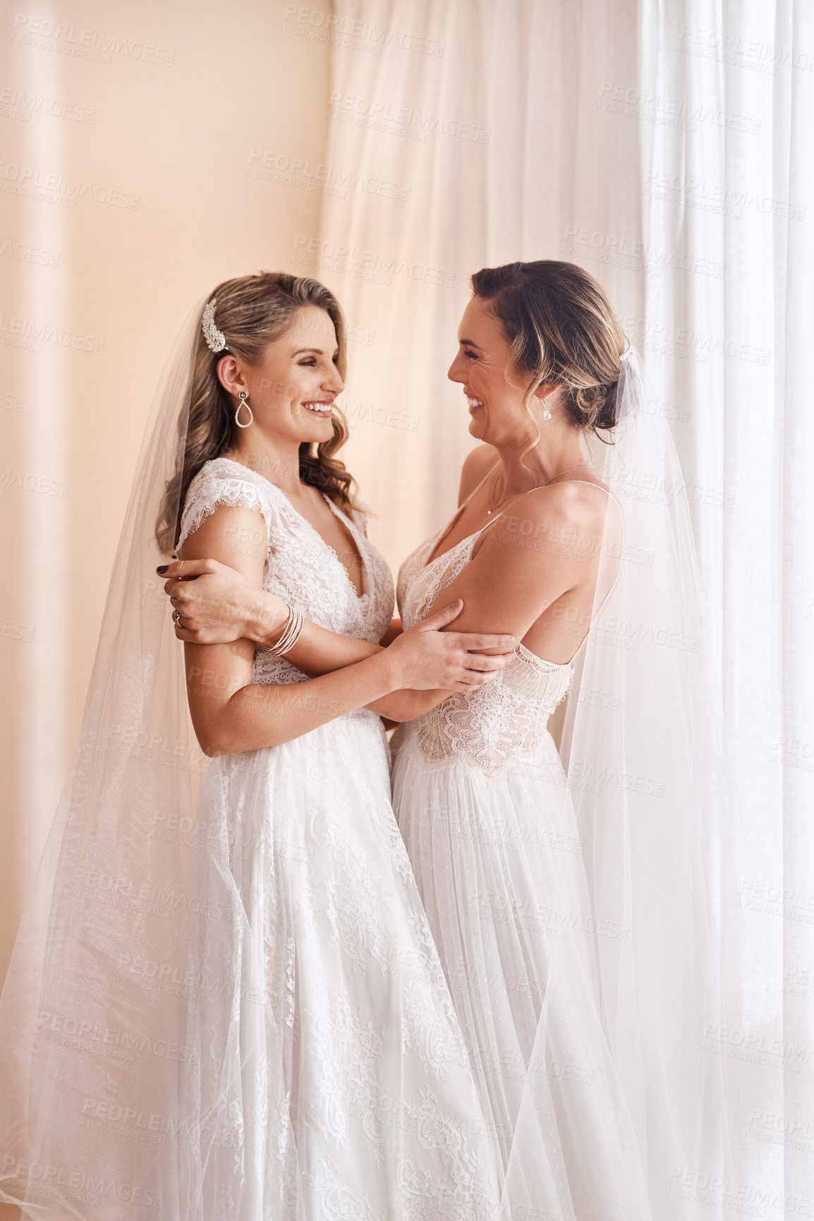 Buy stock photo Cropped shot of two attractive young brides holding each other in excitement before their wedding