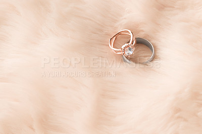 Buy stock photo Shot of two wedding rings on a furry background