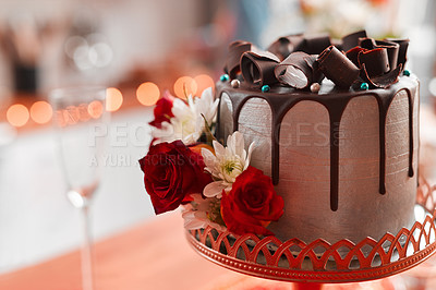 Buy stock photo Chocolate cake, red and roses for wedding reception on pedestal for celebration, social event and dessert. Luxury, cocoa and frosting with flowers for decoration, sweet and confectionary for party