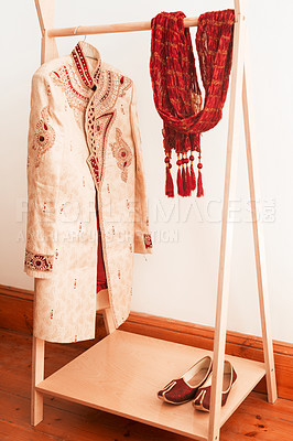 Buy stock photo Shot of men’s clothing hanging on a rack in a bedroom before a traditional Indian wedding ceremony
