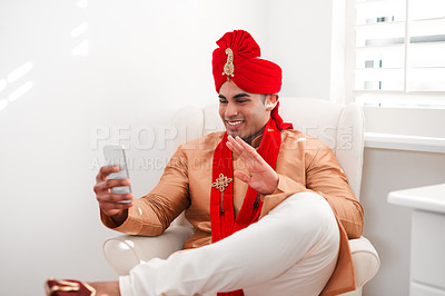 Buy stock photo Shot of a young man waving while using a smartphone on his wedding day