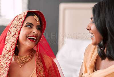 Buy stock photo Laughing, bride and bridesmaid getting ready for a wedding, happy and helping in a room. Support, love and a young woman in traditional Indian clothes for marriage ceremony with a friend or sister