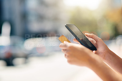 Buy stock photo Cropped shot of an unrecognizable young woman banking online while out in the city