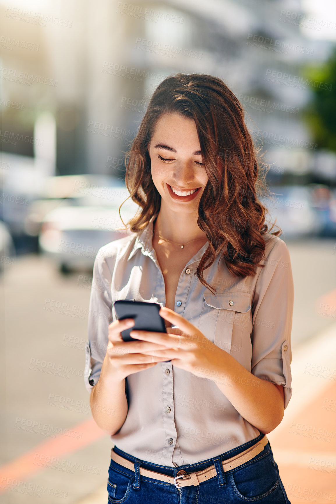 Buy stock photo Cropped shot of an attractive young businesswoman sending text messages during her morning commute to work