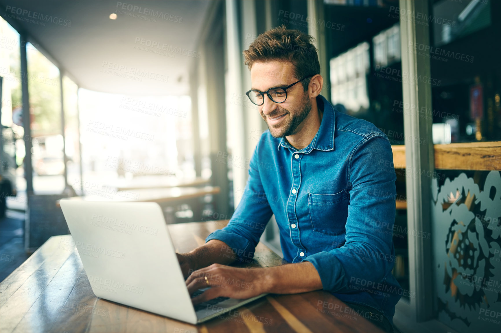 Buy stock photo Business man, laptop and typing at coffee shop with inspiration, happy and remote work in morning. Person, writer or editor with computer, project management and smile with ideas for article at cafe