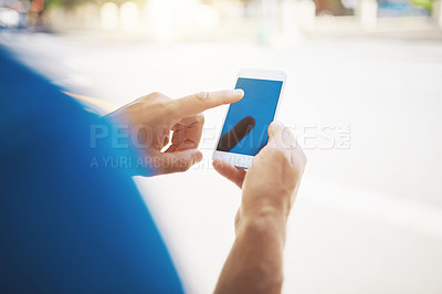 Buy stock photo Cropped shot of an unrecognizable man using his cellphone while out in the city