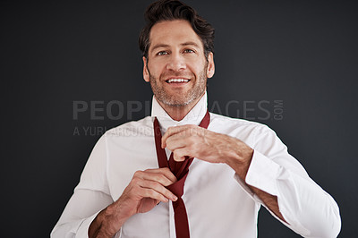 Buy stock photo Cropped shot of an attractive middle aged bridegroom adjusting his necktie in preparation for his wedding